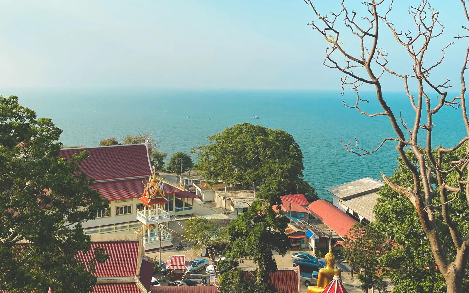 Utsikt över tempeltak och turkost hav i Hua Hin